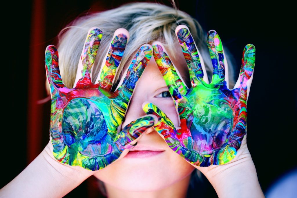lapsi ja värikkäästi maalatut kädet
