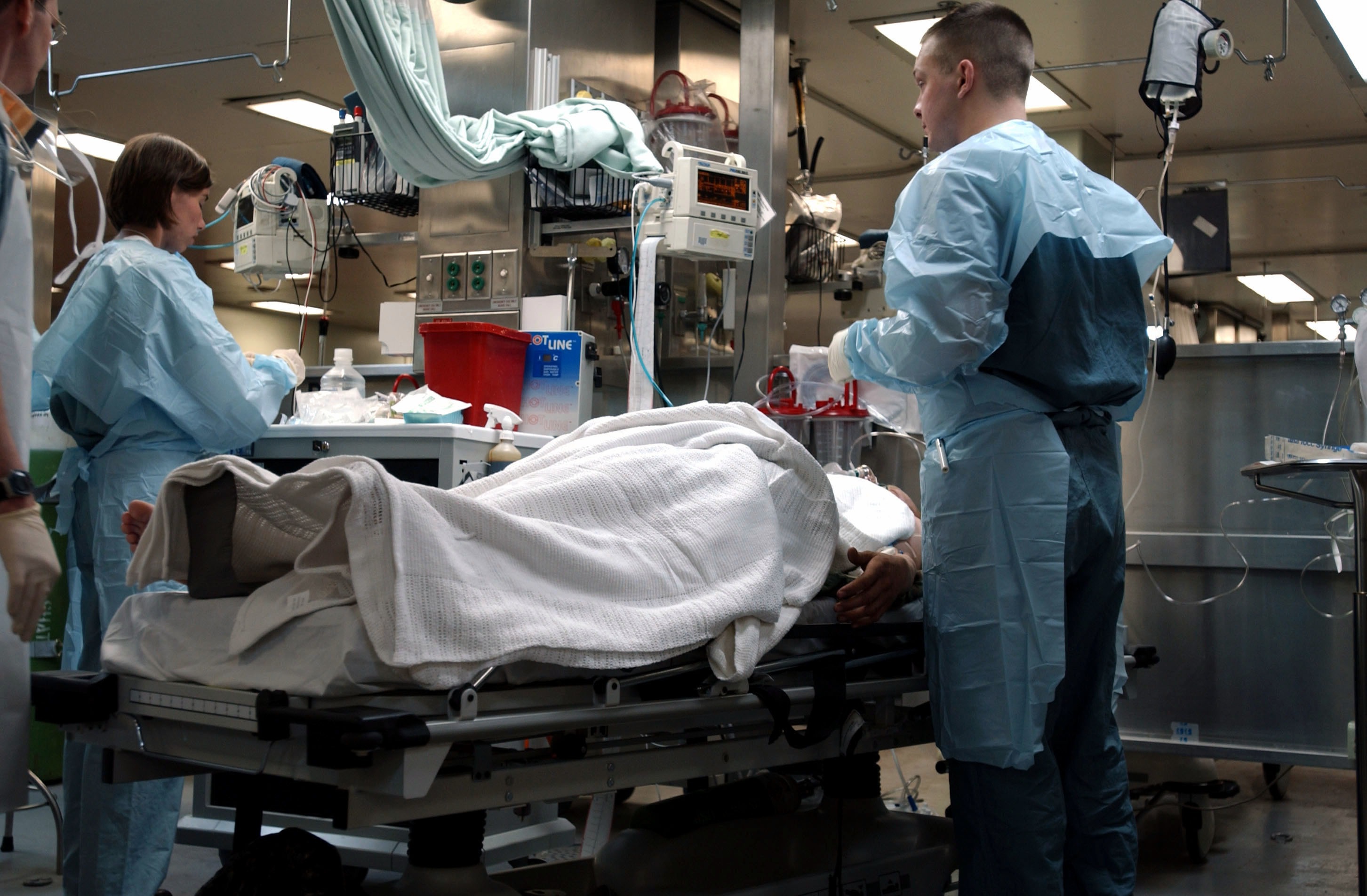 Potilas sairaalan vuoteella henkilökunnan ympäröimänä