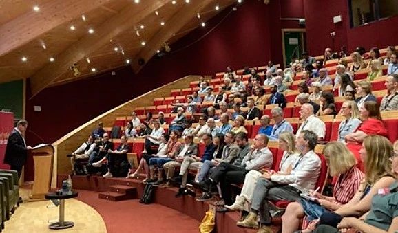 Kongressin osanottajat kuuntelevat puhujaa auditoriossa